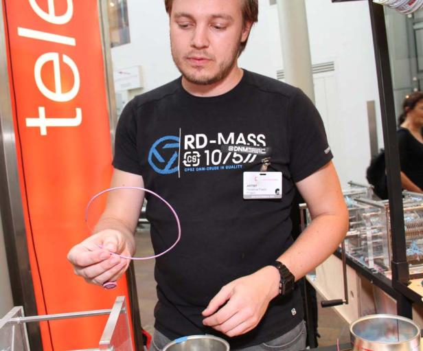 Ein Mann hält einen pinkfarbenen Kunststoffring in der Hand.