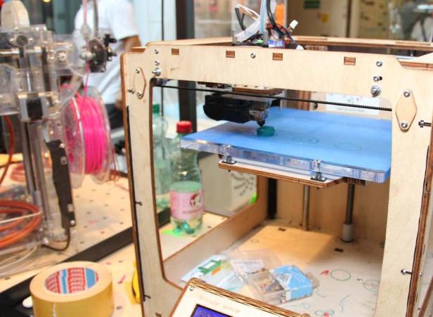 Ein 3D-Drucker druckt ein kleines, blaues Objekt.