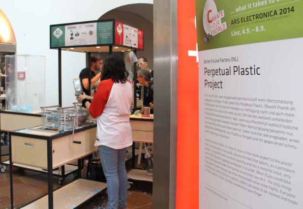 Besucher betrachten und nutzen eine Maschine des „Perpetual Plastic Project“ auf der Ars Electronica 2014 in Linz.