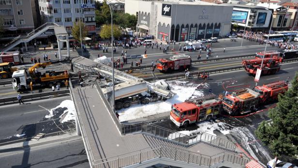 Ein Tanklastwagen ist auf einer Straße umgekippt, Feuerwehrfahrzeuge sind vor Ort.