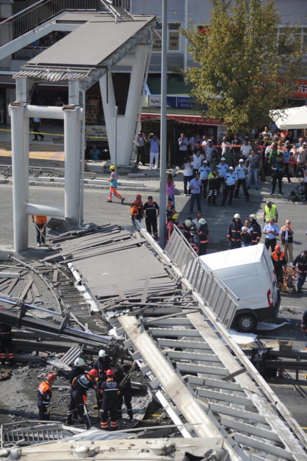 Nach dem Einsturz einer Fußgängerbrücke arbeiten Rettungskräfte vor Ort.