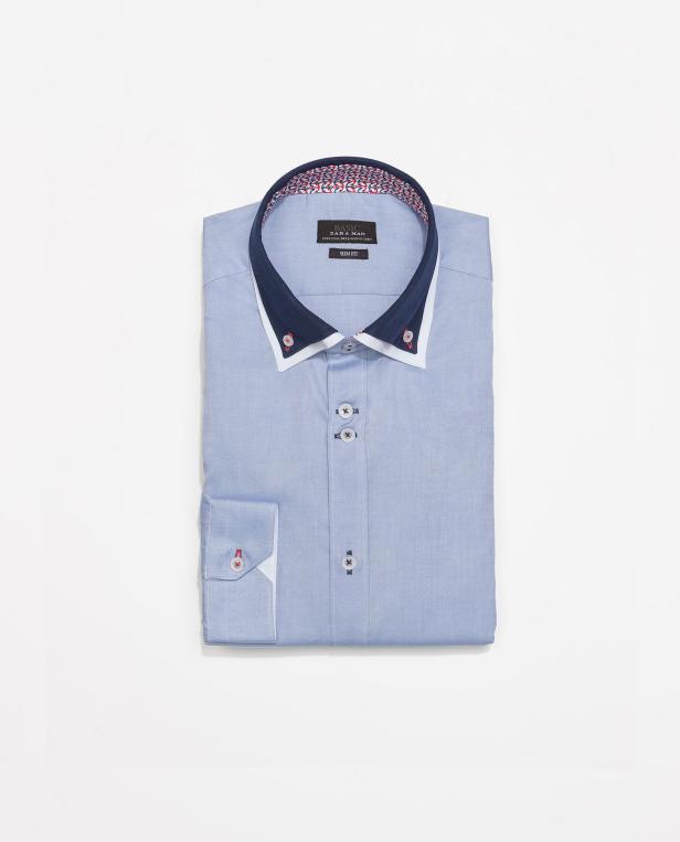 Ein hellblaues, langärmeliges Hemd von Zara Man, Slim Fit, liegt gefaltet auf einem weißen Hintergrund.