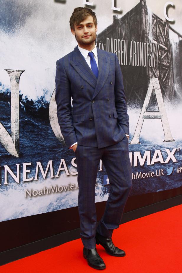 Douglas Booth posiert vor einem Filmplakat für „Noah“.