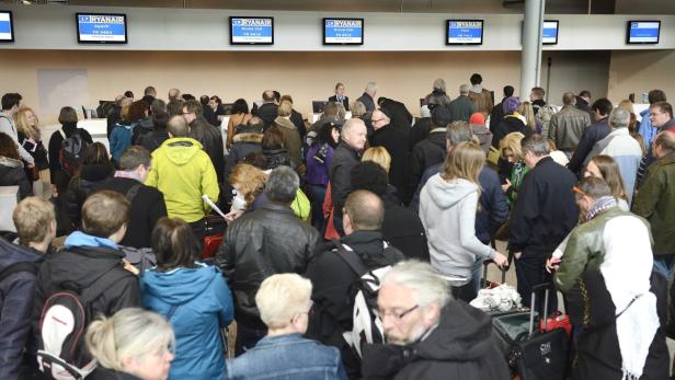 Eine große Menschenmenge wartet in der Abflughalle eines Flughafens auf ihren Ryanair-Flug.