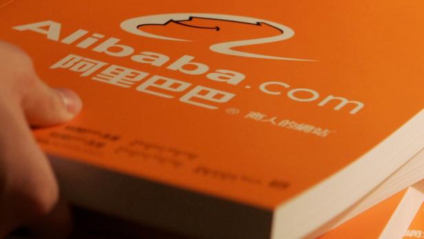 Ein orangefarbenes Buch mit dem Alibaba-Logo und der Aufschrift „Alibaba.com“.