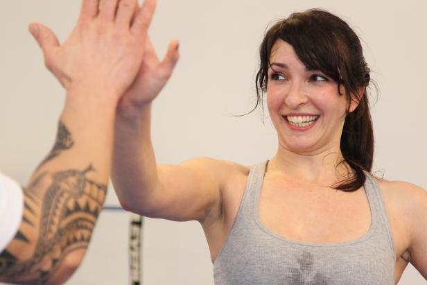 Eine Frau freut sich über ein High-Five nach dem Training.