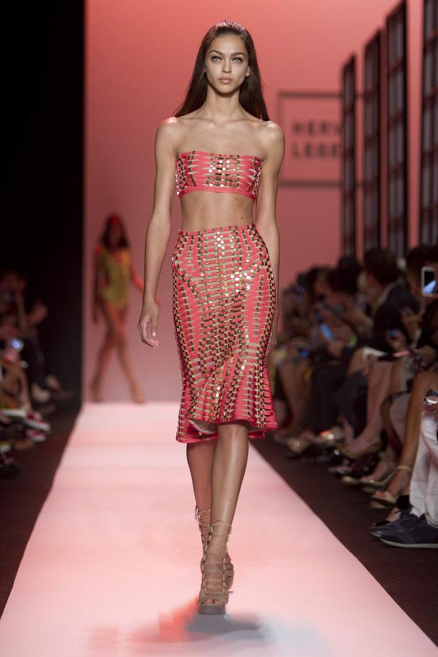 Ein Model präsentiert ein korallfarbenes Ensemble auf dem Laufsteg.