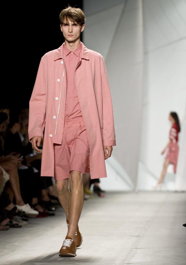 Ein Mann in einem rosa Anzug und braunen Schuhen läuft über einen Laufsteg.