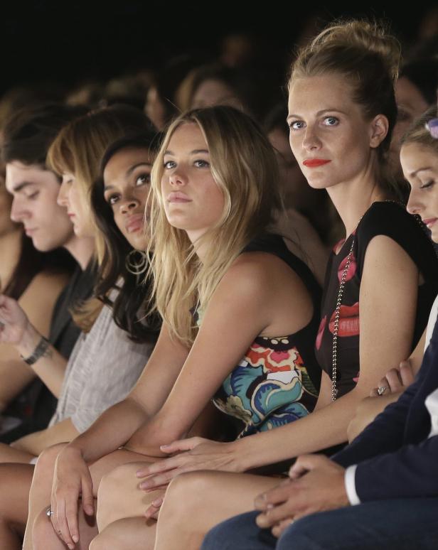 Zuschauerinnen sitzen bei einer Modenschau in der ersten Reihe.