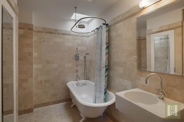 Ein Badezimmer mit einer freistehenden Badewanne und beigen Fliesen.