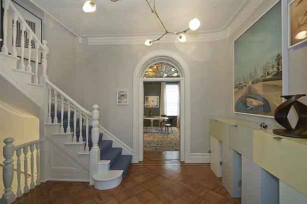 Ein Eingangsbereich mit Treppe, Kunstwerken und Blick in ein Esszimmer.