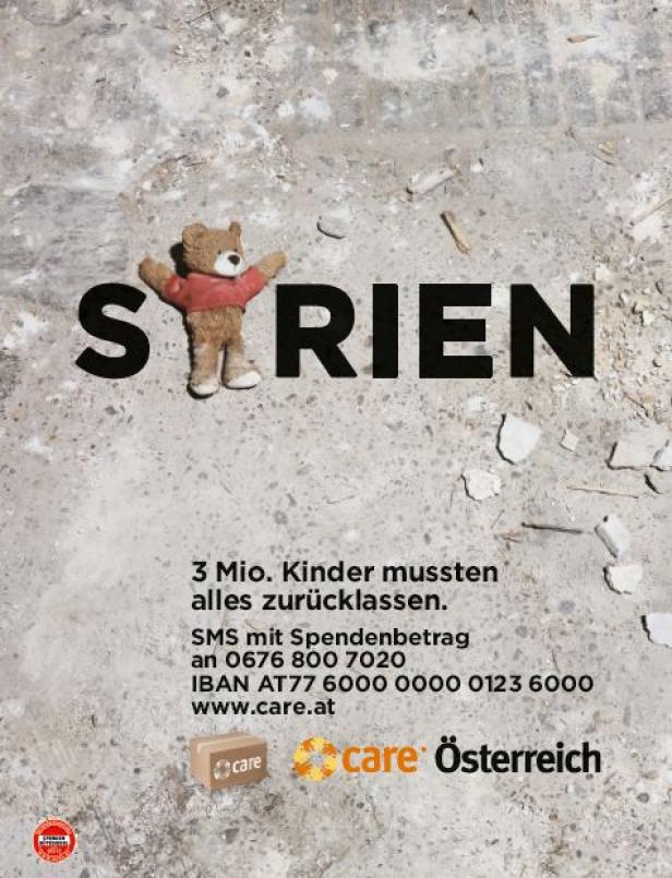 Ein Teddybär steht vor dem Wort „Syrien“ auf einem zerstörten Untergrund.