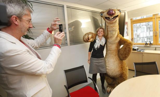 Ein Mann fotografiert eine Frau, die neben einer Sid-Figur aus „Ice Age“ steht.