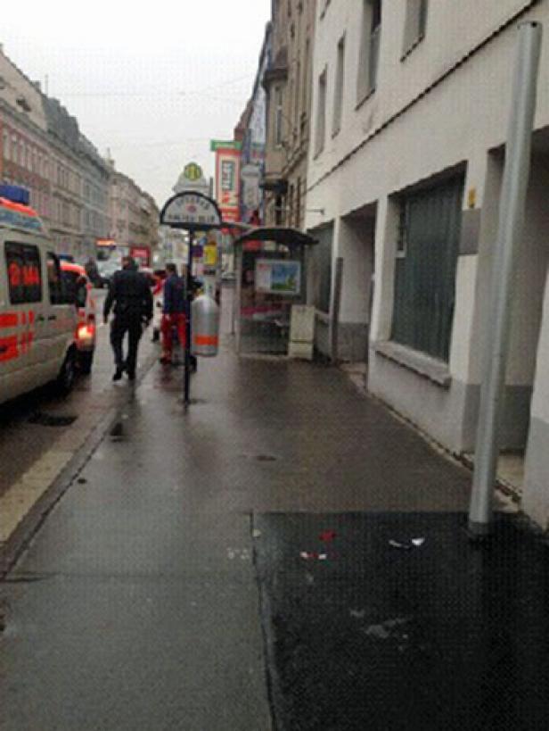 Ein regnerischer Tag in der Stadt mit einem Krankenwagen und Passanten.