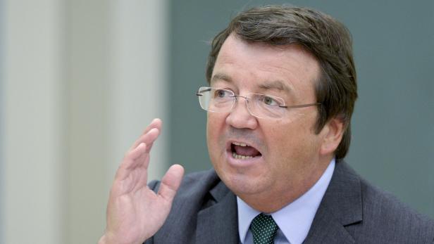 Ein Mann mit Brille gestikuliert und spricht.