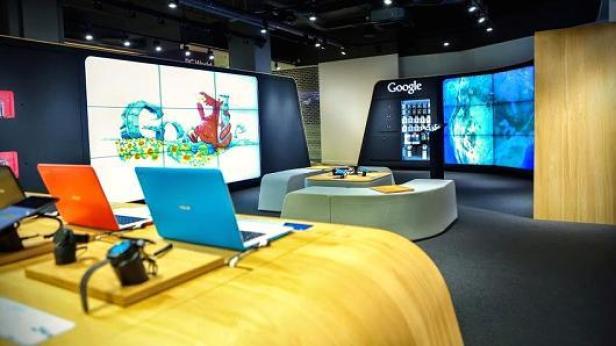 Innenansicht eines Google-Ausstellungsraums mit Laptops und Bildschirmen.