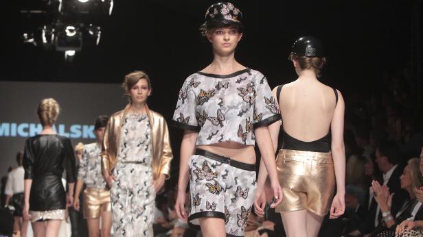 Models präsentieren Mode auf einem Laufsteg.