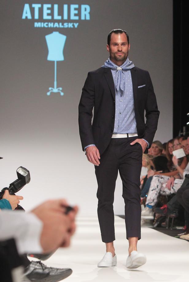 Ein Mann in einem Anzug von Atelier Michalsky läuft über einen Laufsteg.