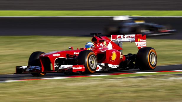 Ein roter Ferrari-Formel-1-Rennwagen fährt auf einer Rennstrecke.
