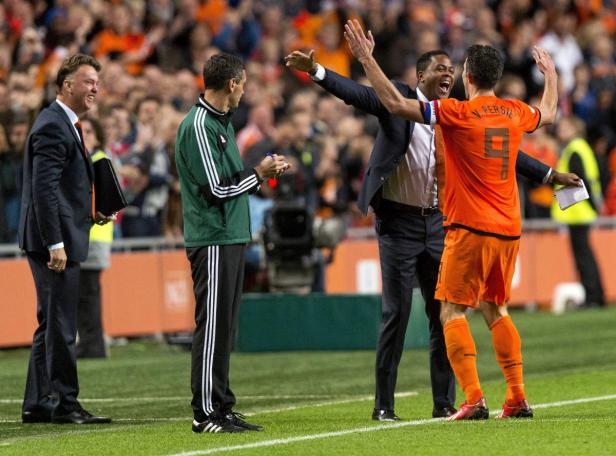 Louis van Gaal und andere Trainer beobachten Robin van Persie auf dem Fußballfeld.
