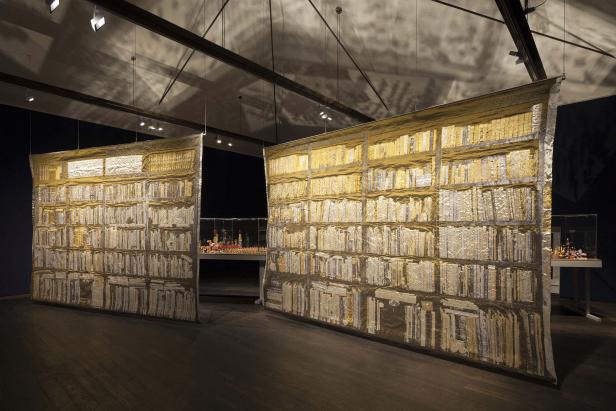 Eine Installation zeigt zwei Vorhänge mit dem Aufdruck eines Bücherregals in einer Ausstellung.