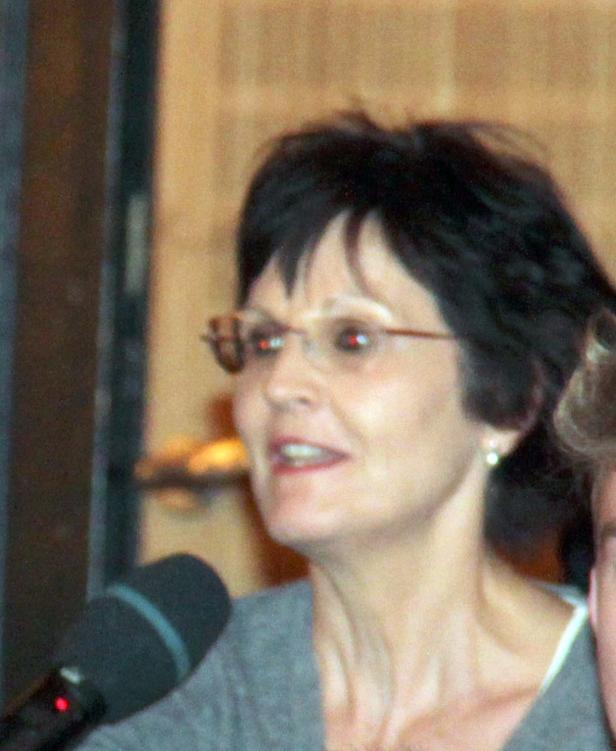 Eine Frau mit Brille spricht in ein Mikrofon.