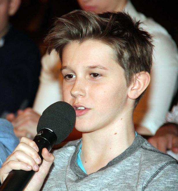 Ein junger Mann spricht in ein Mikrofon.