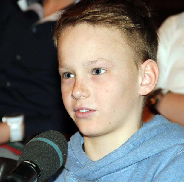 Ein junger Mann spricht in ein Mikrofon.