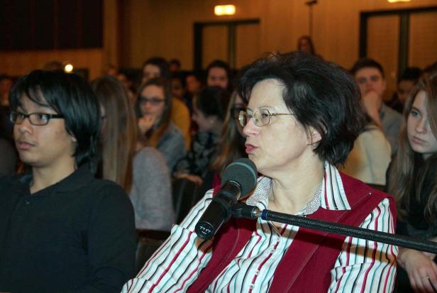 Eine Frau spricht bei einer Veranstaltung in ein Mikrofon.