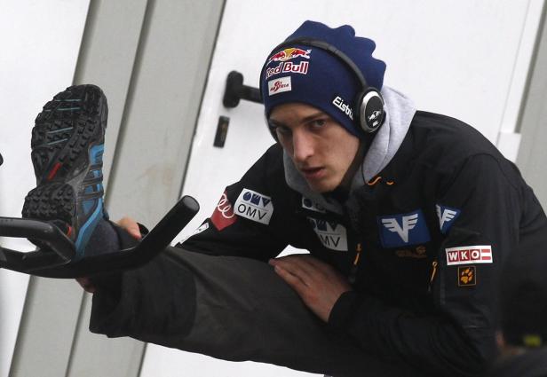 Schlierenzauer of Austria stretches prior to his f