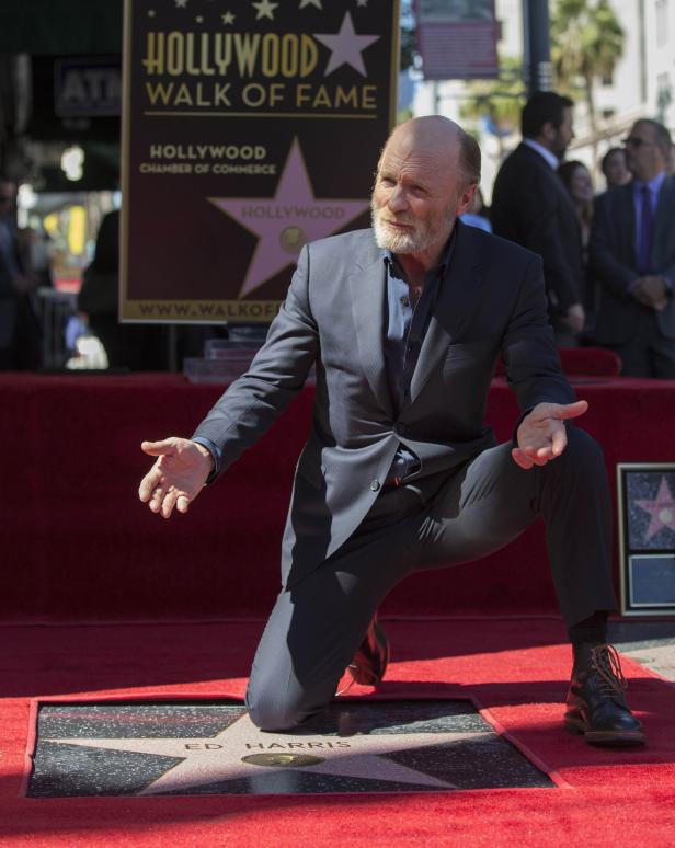 Ed Harris kniet auf dem Hollywood Walk of Fame neben seinem Stern.