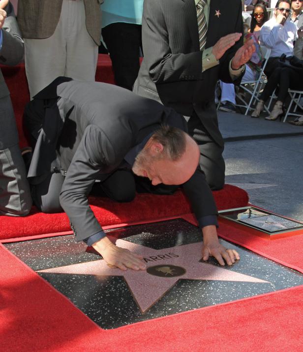 Ed Harris kniet auf dem Hollywood Walk of Fame neben seinem Stern.