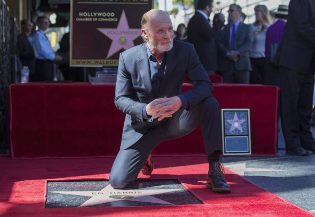 Ed Harris kniet auf dem Hollywood Walk of Fame neben seinem Stern.