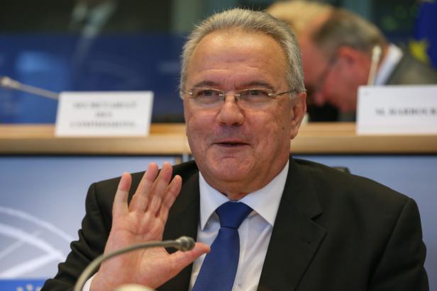 Ein Mann im Anzug gestikuliert während einer Konferenz.