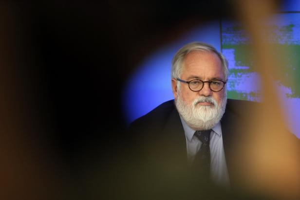 Ein Mann mit Brille und Bart sitzt vor einem blauen Hintergrund.