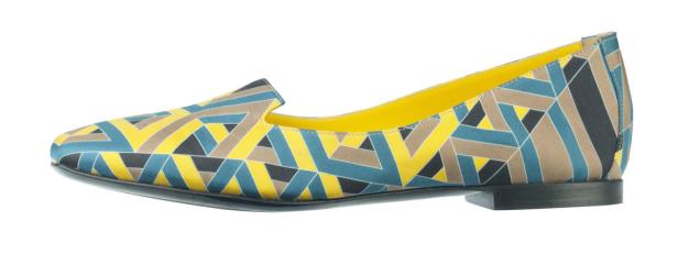 Ein Slipper mit geometrischem Muster in Gelb, Blau und Braun.