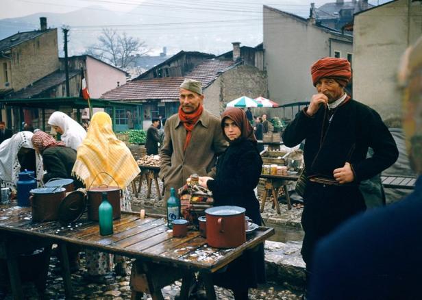 Menschen verkaufen Milch und andere Waren auf einem Markt im Freien.