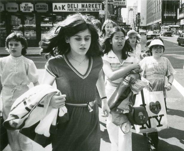 Eine Gruppe junger Frauen überquert eine Straße in der Nähe eines „A&K Deli Market“ in New York.