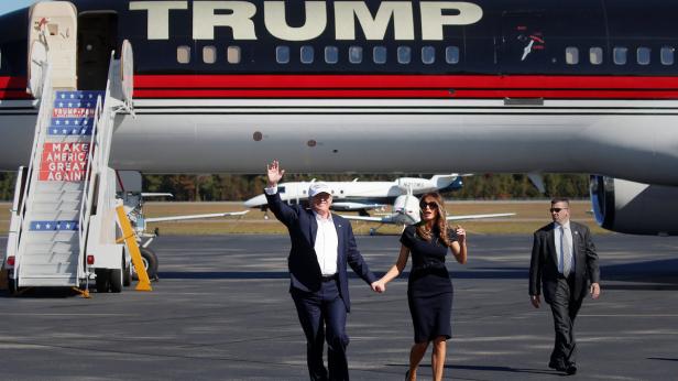 Donald Trump und Melania Trump verlassen gemeinsam ein Flugzeug mit der Aufschrift „Trump“.