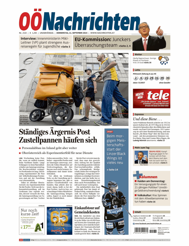 Zwei Postboten schieben einen Karren mit großen, gelben Posttaschen durch die Stadt.