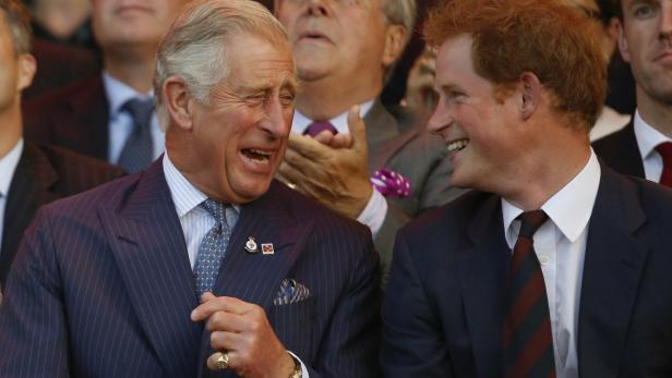 König Charles und Prinz Harry lachen miteinander.