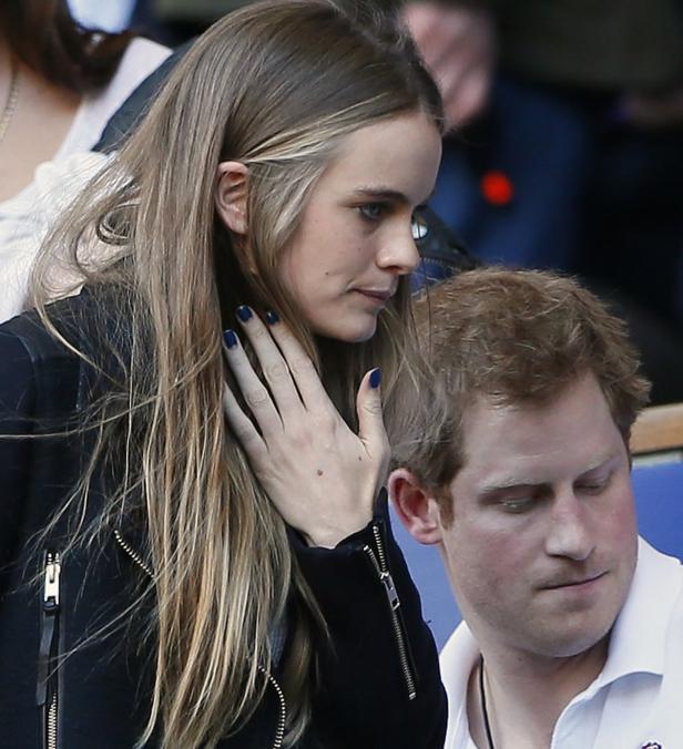 Prinz Harry sitzt neben einer Frau mit blonden Haaren.