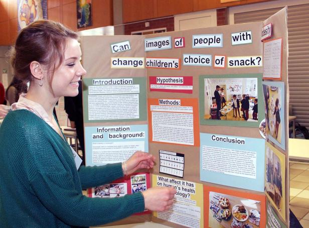 Eine junge Frau betrachtet eine Präsentation über den Einfluss von Bildern auf die Ernährung von Kindern.