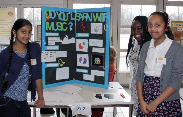 Drei Schülerinnen präsentieren ein Projekt zum Thema „Lernen mit Musik“.