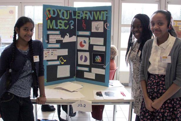Drei Schülerinnen präsentieren ein Projekt zum Thema Lernen mit Musik.