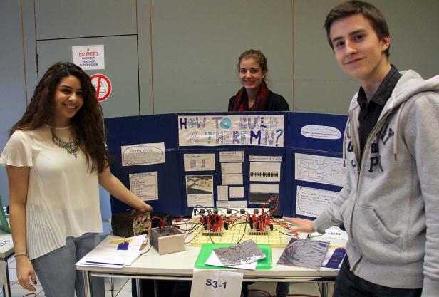 Drei Jugendliche präsentieren ein Projekt zum Thema „How to build a Theremin?“.