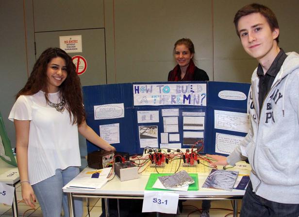 Drei junge Leute präsentieren ein Projekt zum Bau eines Theremins.