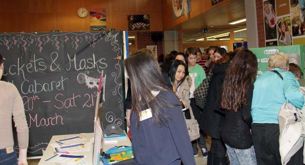 Menschen stehen an einem Stand für „Tickets & Masks Cabaret“.