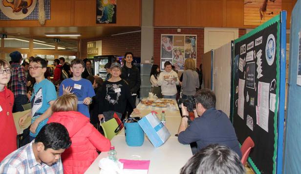 Eine Gruppe von Schülern steht an einem Tisch mit Essen und Getränken.
