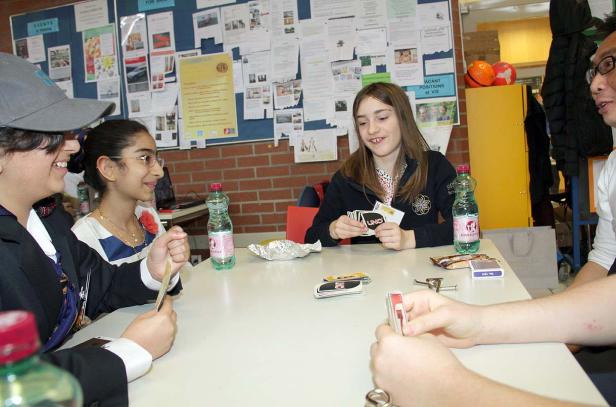 Eine Gruppe von Schülern spielt Uno an einem Tisch.
